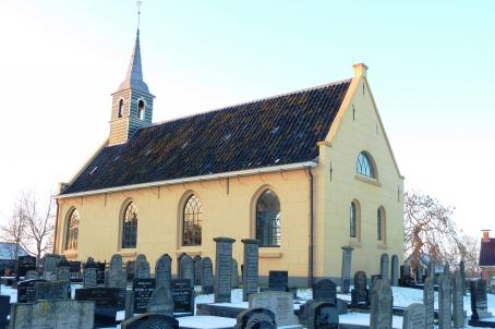 Simple yellow church in a graveyard 
